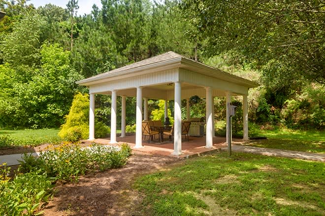 A charming gazebo surrounded by lush greenery in a tranquil garden setting.
