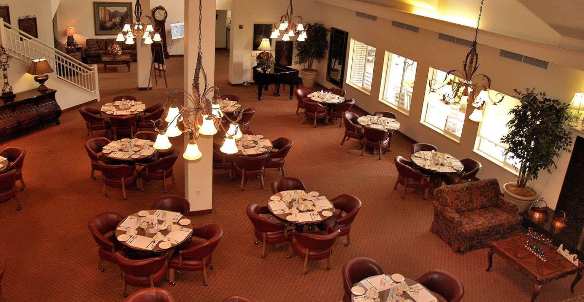 An elegant restaurant dining area with neatly arranged tables and soft lighting.