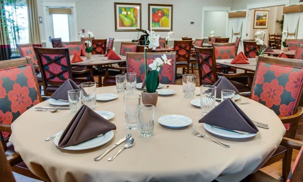 A well-arranged dining table set in a restaurant with glasses, napkins, and plates.
