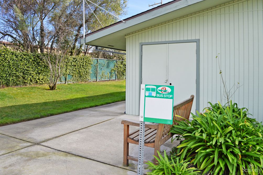 A house with a well-maintained backyard and a for sale sign in the yard.