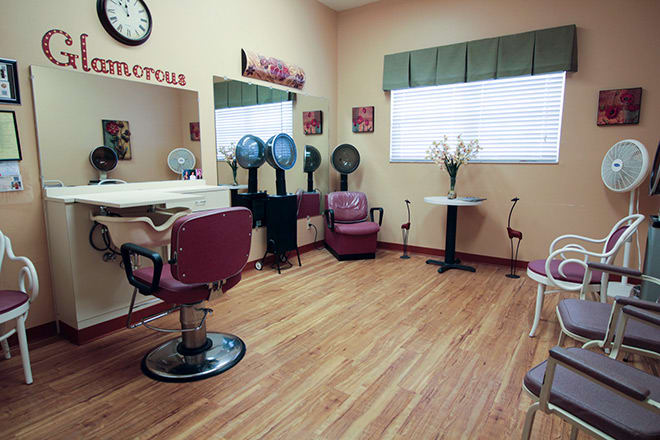 A cozy hair salon with chairs, mirrors, and hairdryers set up for clients.