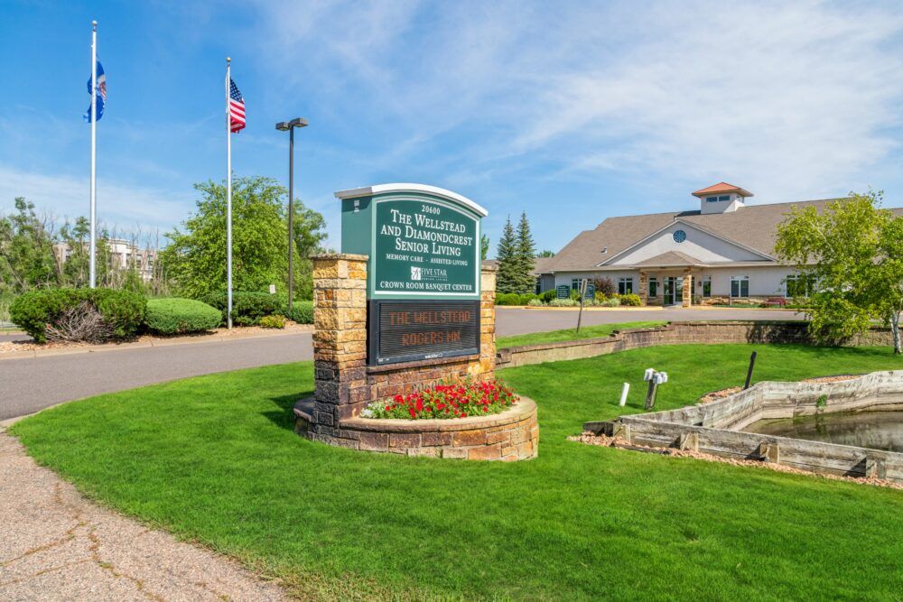 Entrance to a golf club with a welcoming sign and well-maintained landscape.