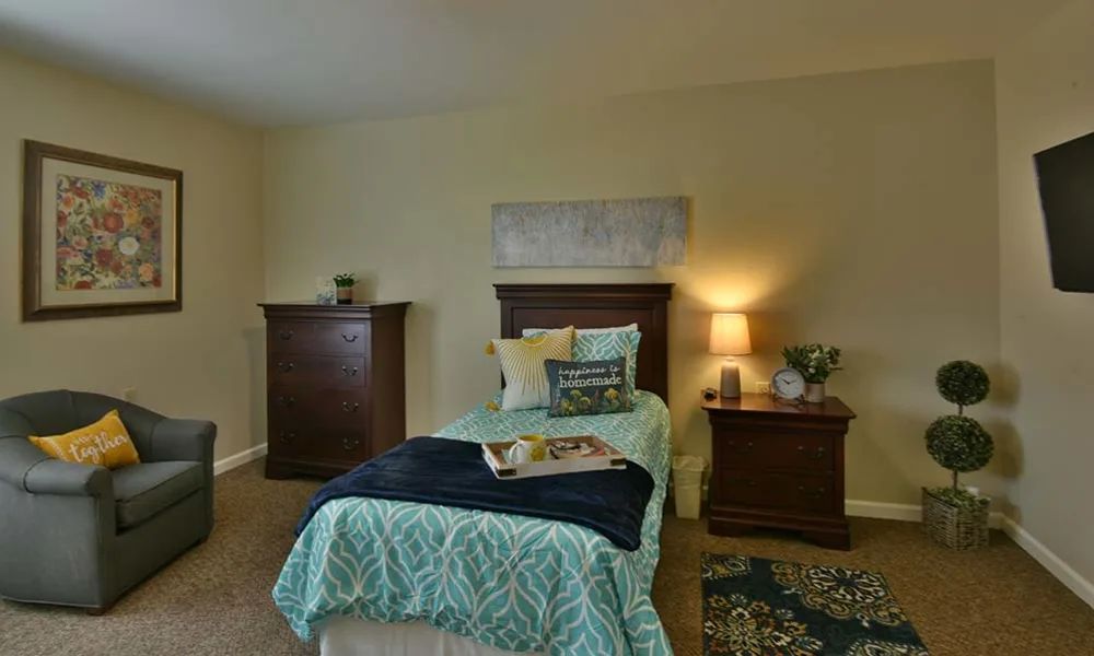 A cozy bedroom with a single bed and warm lighting.