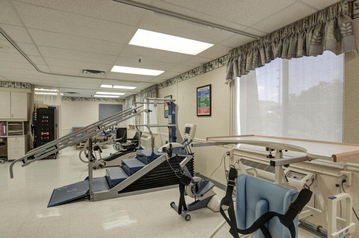 A rehabilitation room equipped with exercise machines and physical therapy tools.