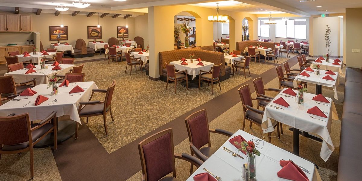 A well-arranged restaurant dining area with neatly set tables and comfortable seating.