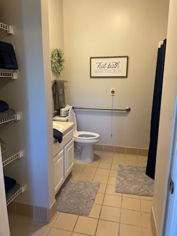 A tidy and well-decorated bathroom with neatly arranged towels, a toilet, and a sink.
