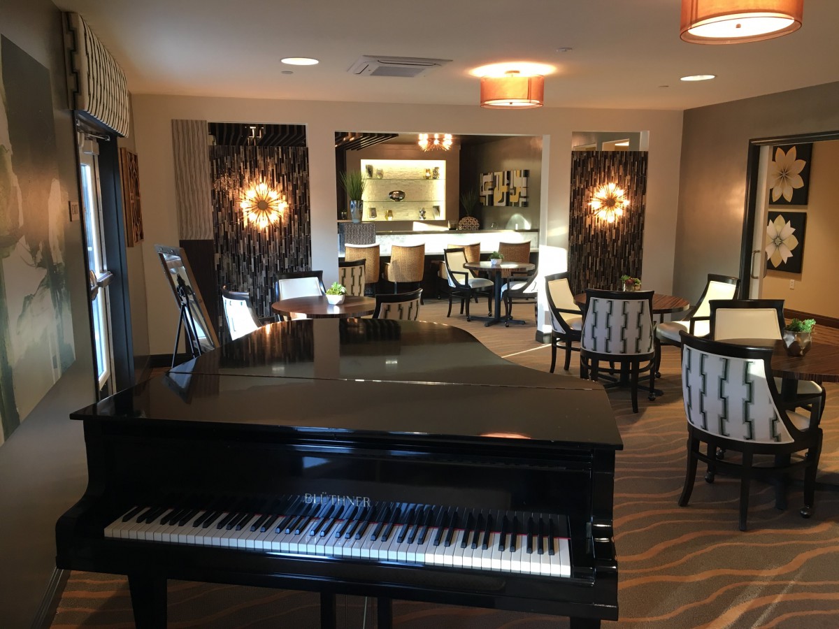 A stylish lounge featuring a grand piano and modern seating arrangements.