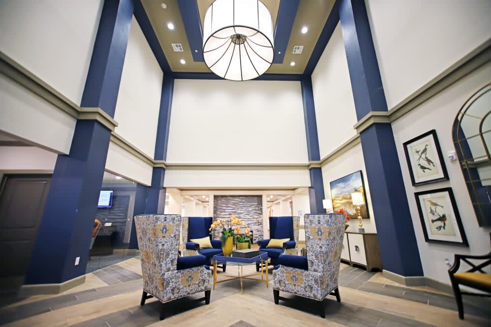A modern lobby with elegant seating and a large chandelier.
