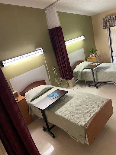 A well-equipped patient room featuring two beds and essential medical amenities.