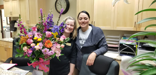 Two friends posing together with a beautiful bouquet of flowers.