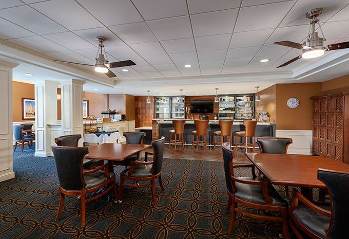 A cozy dining area with a bar, featuring comfortable seating and warm lighting.