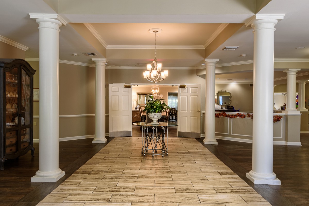 Elegant lobby area with columns and a chandelier.