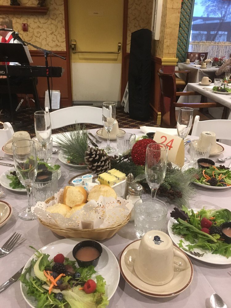 A beautifully set dinner table at a formal event with salads, bread, and elegant decorations.