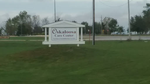 Signage for the Oskaloosa Care Center in a grassy area.