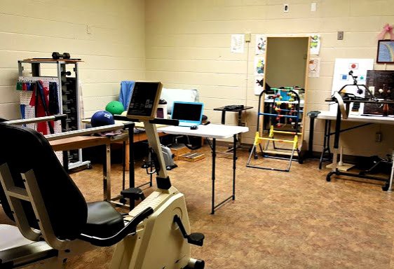 A physical therapy and rehabilitation room equipped with exercise machines and therapy tools.