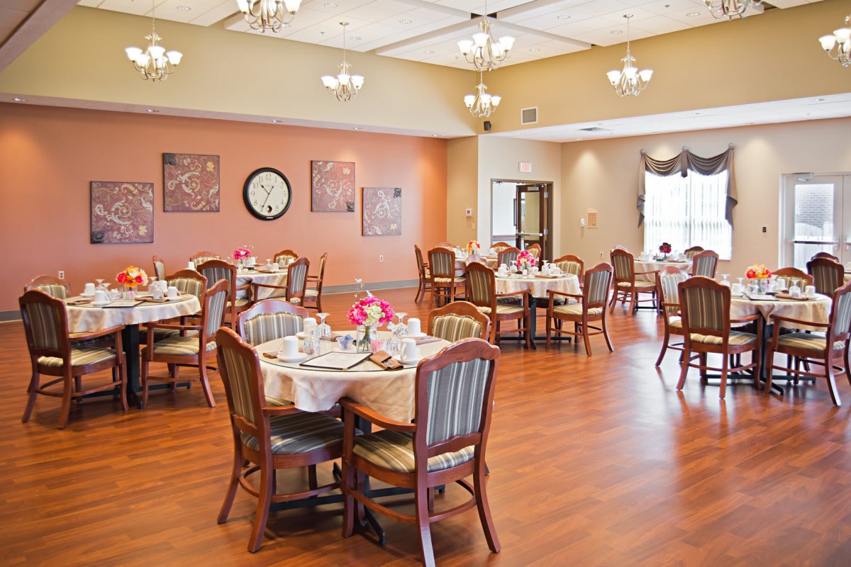 An elegant dining room with tables set for a meal, showcasing a warm and inviting atmosphere.