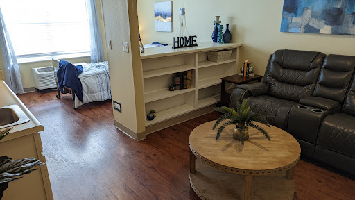 A cozy living room setup featuring a plush couch, decorative shelf, and a wooden coffee table.