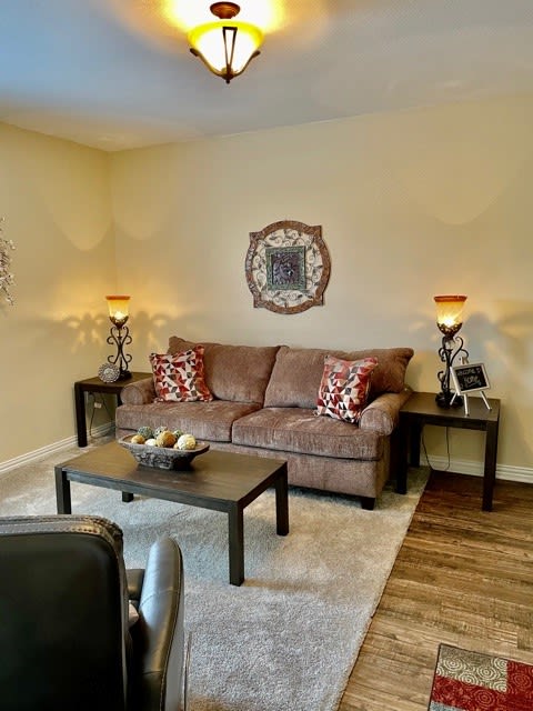 A cozy living room with a sofa, coffee table, and ambient lighting.