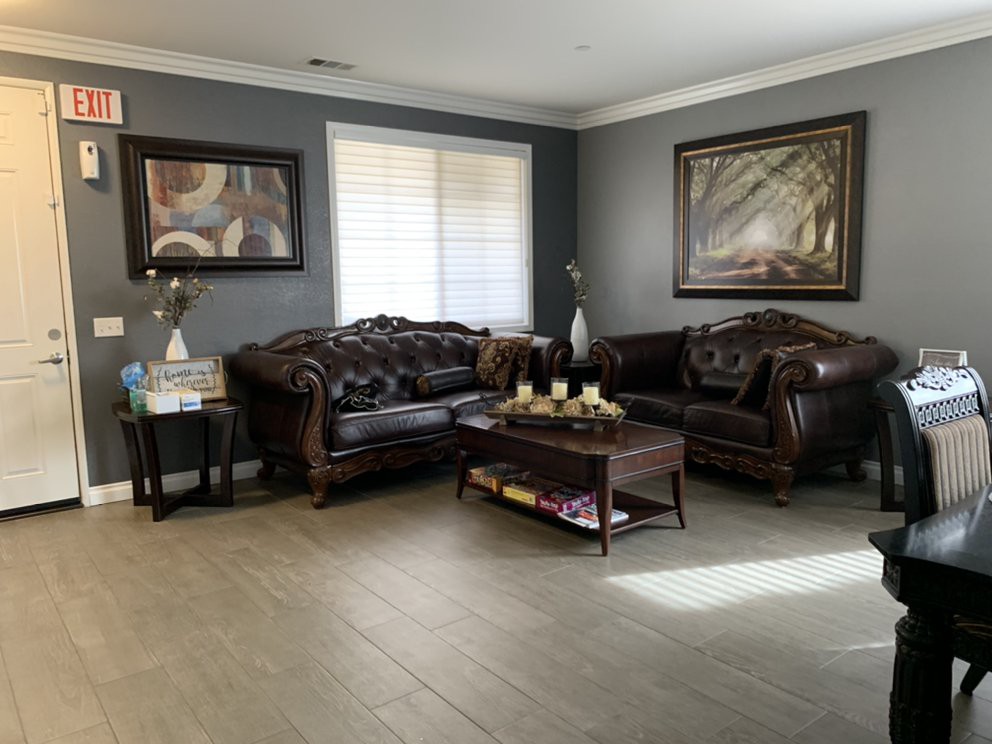 A well-decorated living room with leather sofas, a central coffee table, and framed artwork on the walls.