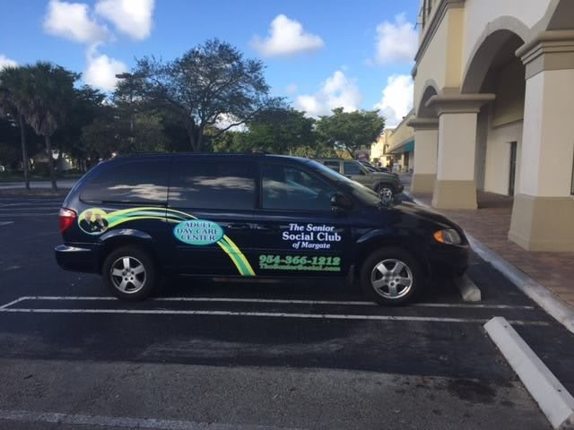 A van with business advertising parked in a lot.