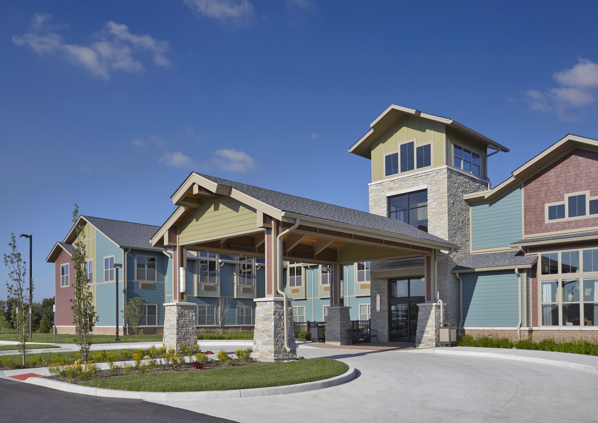 A modern residential building with a prominent entrance and landscaped surroundings.