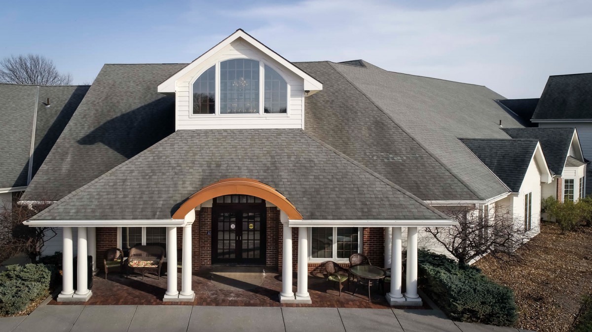 A beautiful house with a large roof, prominent entrance, and columns.