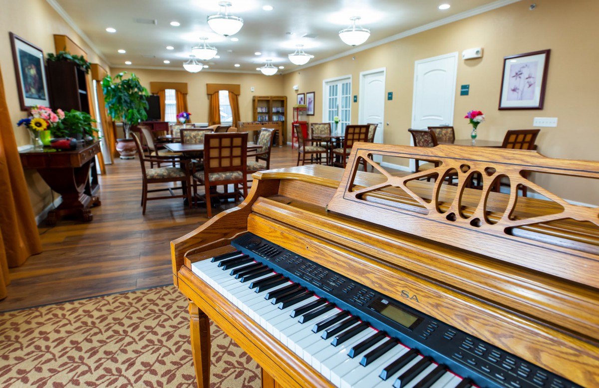 A cozy lounge and dining area featuring a piano and elegant decor.