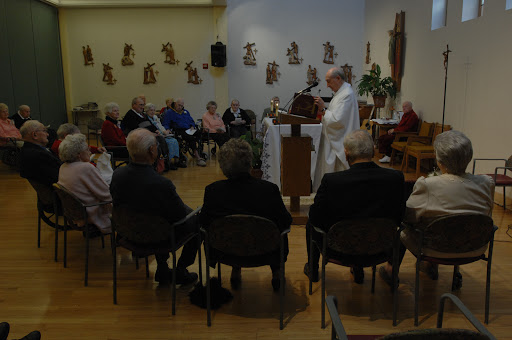 A community gathering during a religious ceremony, with members of the audience attentive to the speaker.