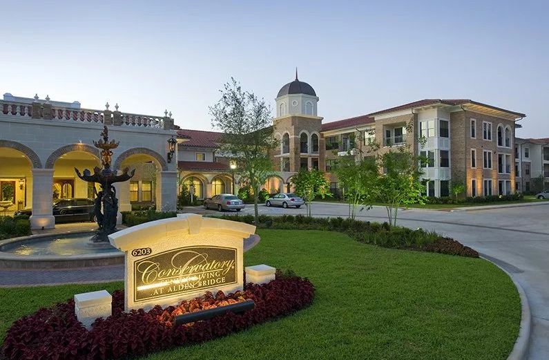A luxurious hotel building with well-maintained lawns during the evening.