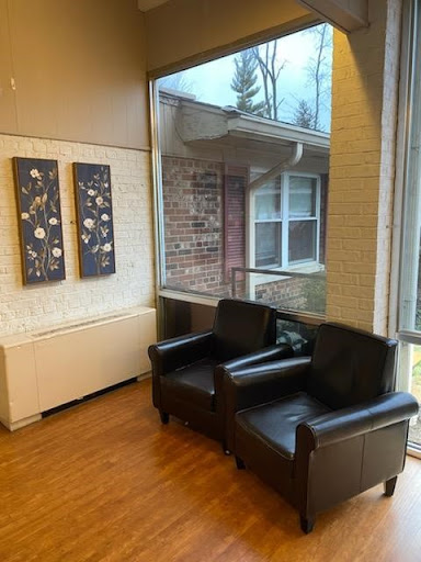 A cozy lounge area featuring black leather chairs and modern artwork.
