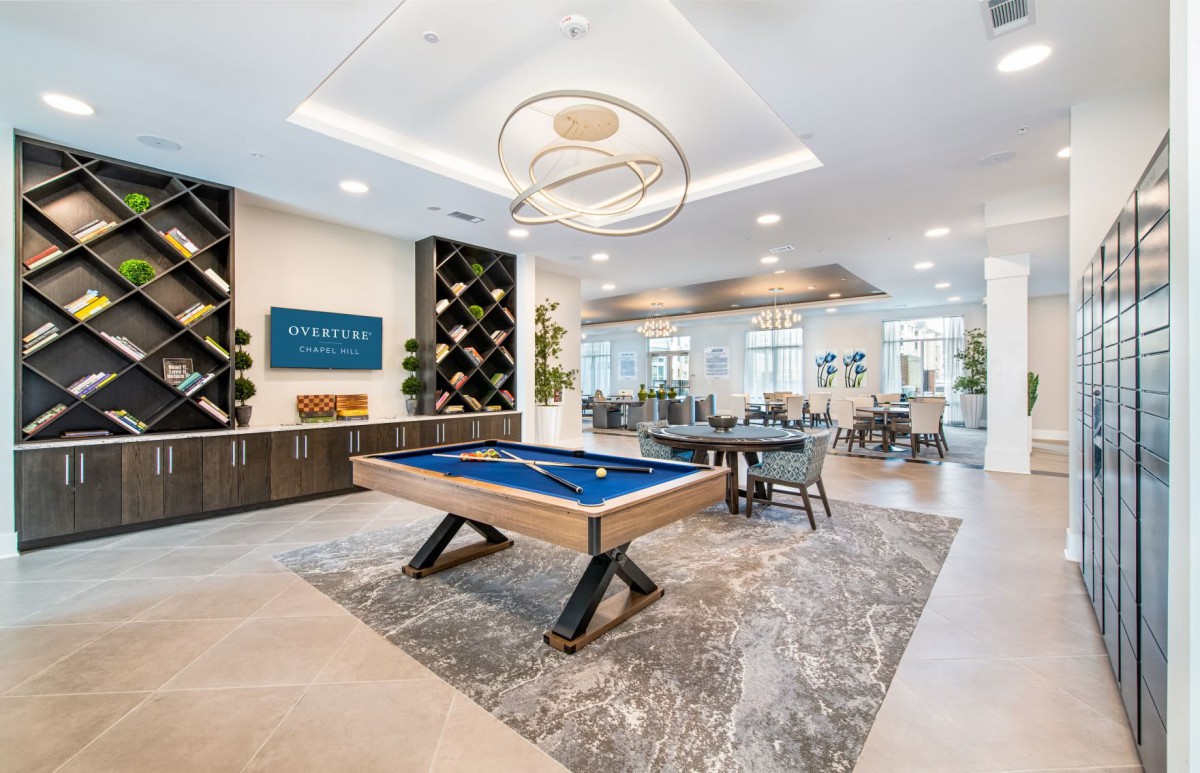 Modern game room with a billiards table and stylish lounge area.