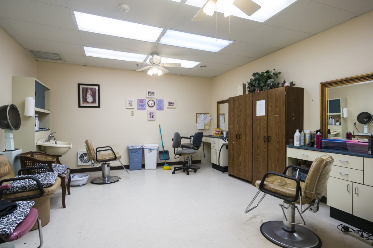 A well-lit hair salon interior with chairs and mirrors, featuring skylights and storage cabinets.