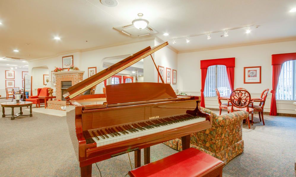 A grand piano in an elegantly decorated music room with red accents.