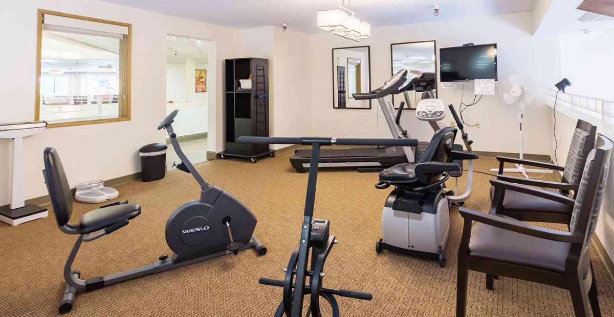 A small gym with various exercise equipment, including stationary bikes and a treadmill.