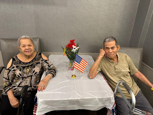 An elderly couple enjoying a moment together at a decorated table.