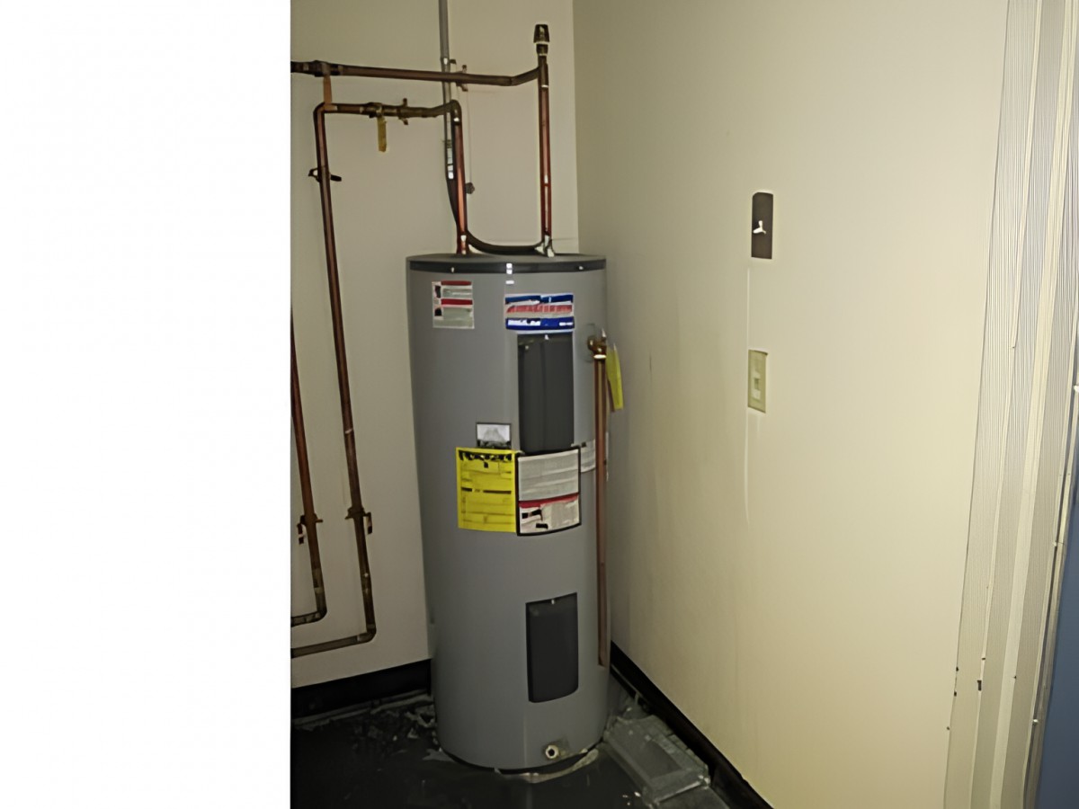 A water heater installed in a utility room with visible plumbing pipes.
