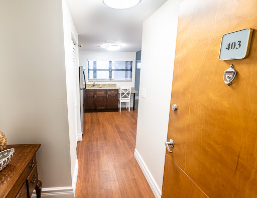A welcoming hallway leading into a spacious apartment with a view of the kitchen.
