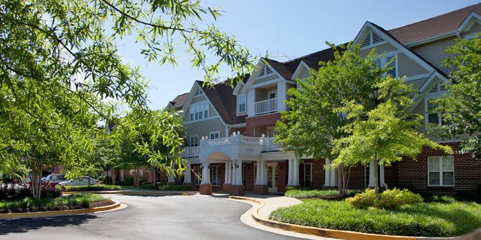 A scenic view of a residential building surrounded by greenery on a sunny day.