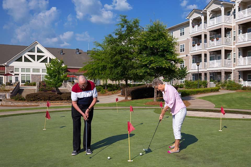 Elderly couple enjoying a game of golf in a residential community.