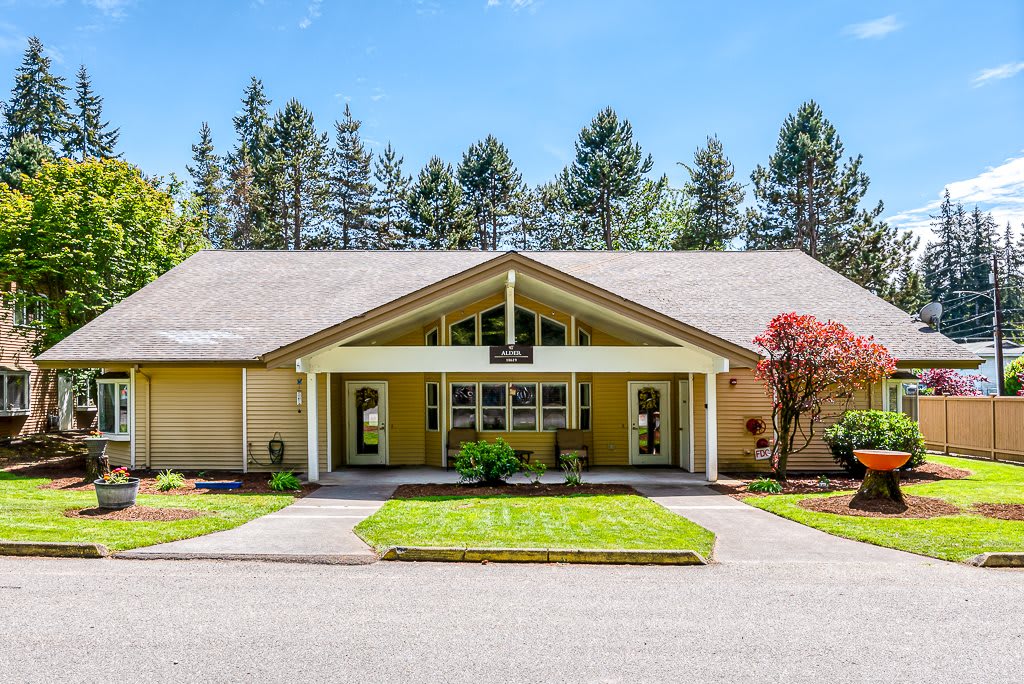 A suburban house with a well-maintained front yard and surrounded by trees.
