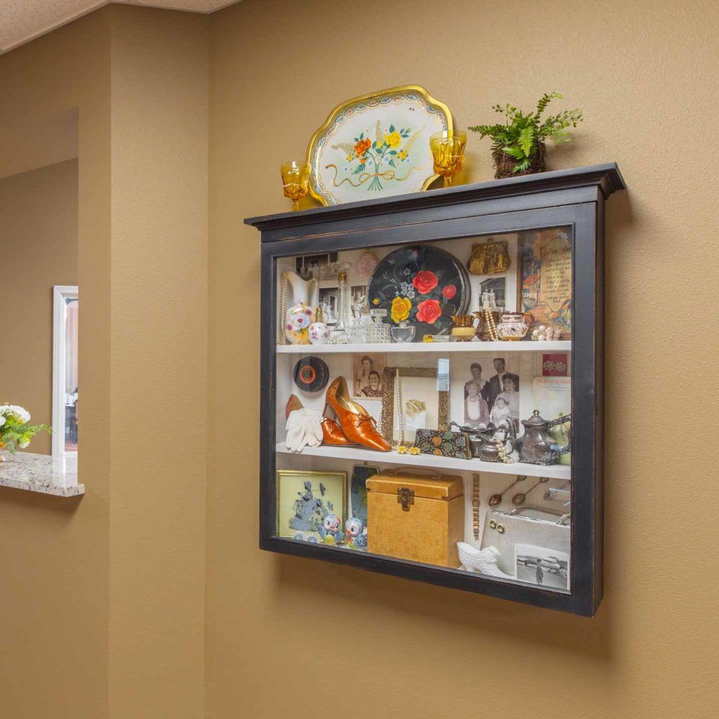 A wall-mounted display case filled with decorative items and collectibles.