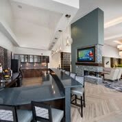 A spacious modern interior featuring a kitchen with a bar area and an open-plan living room.