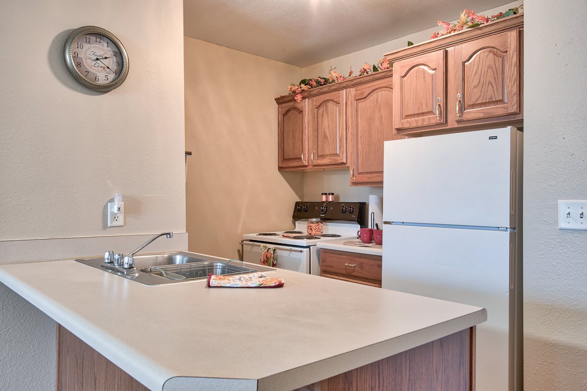 A cozy kitchen with wooden cabinets and a white refrigerator.