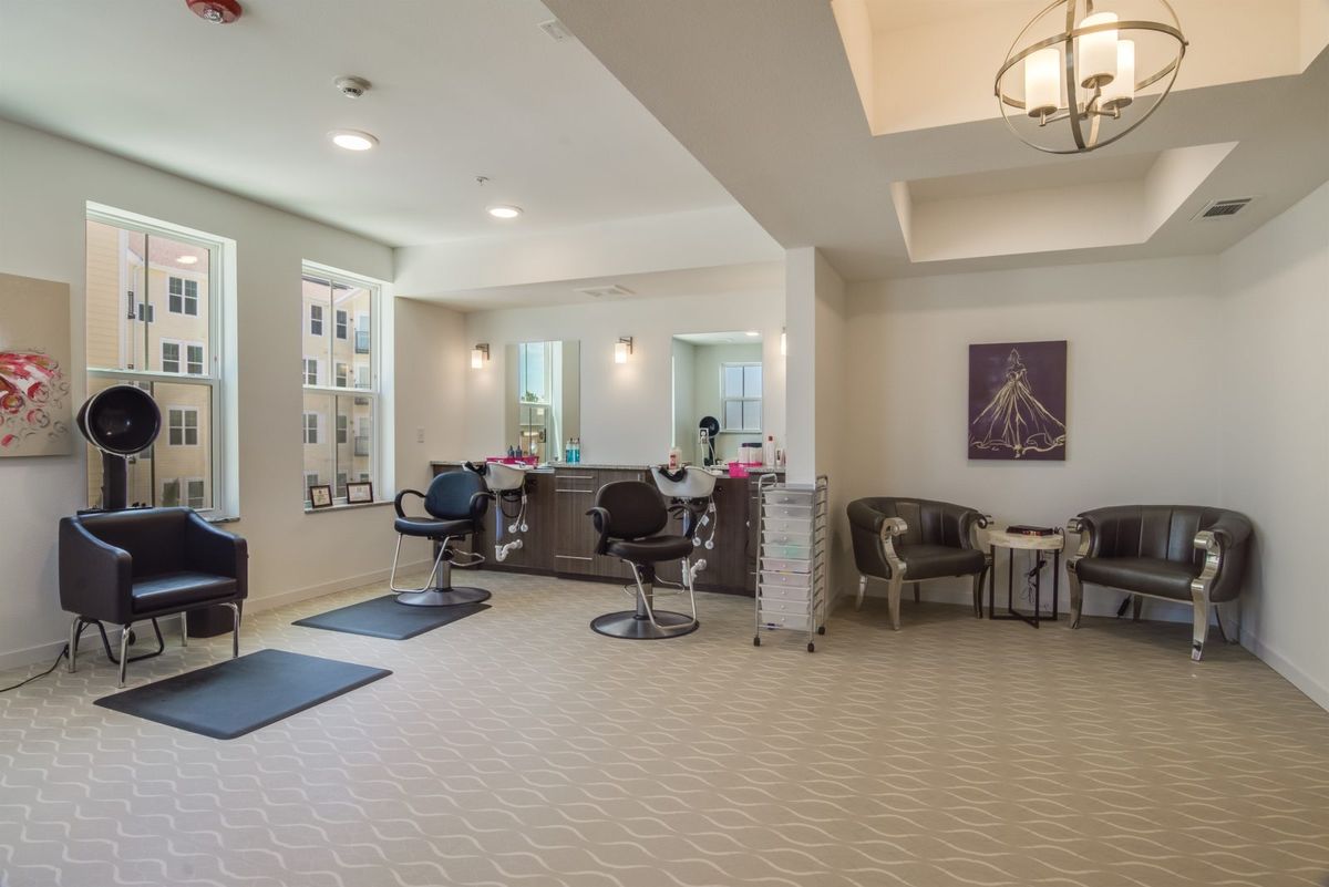 Modern salon interior with styling chairs and a cozy waiting area.
