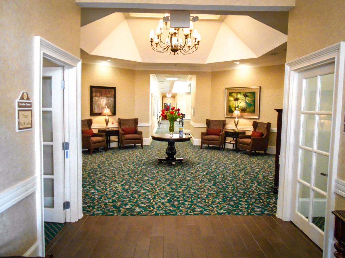 A well-decorated lobby with plush seating, a chandelier, and a central table adorned with flowers.