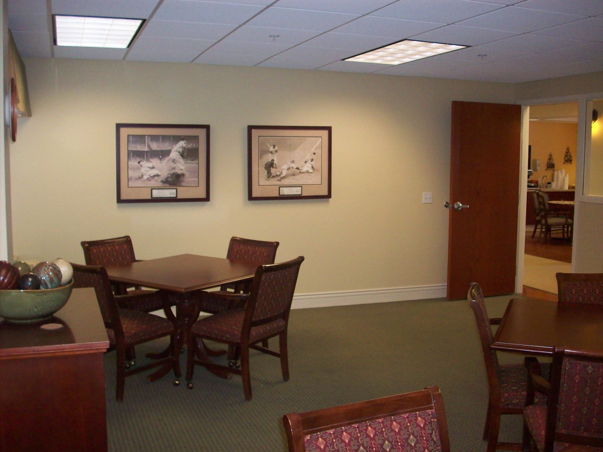 A well-designed office meeting area with a table, several chairs, and framed artwork on the walls.