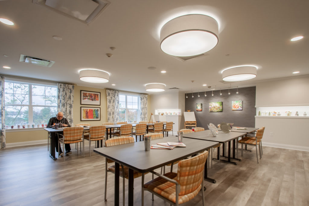 A modern meeting room with tables, chairs, and stylish lighting fixtures.
