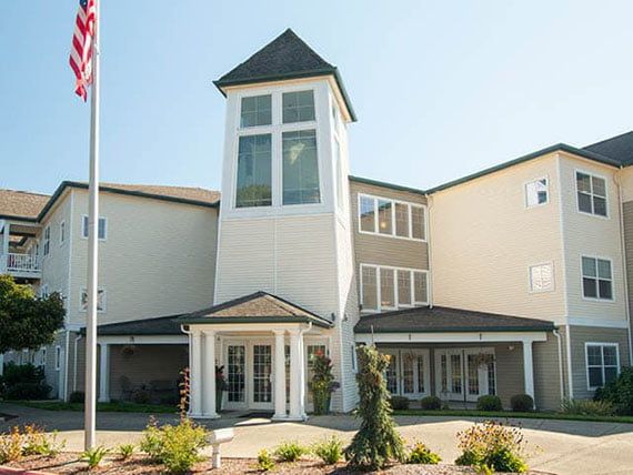 A modern multi-story building with a prominent entrance and flagpole.