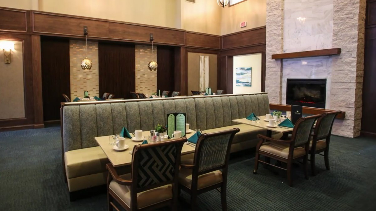 An empty restaurant interior featuring booth seating and neatly set tables.