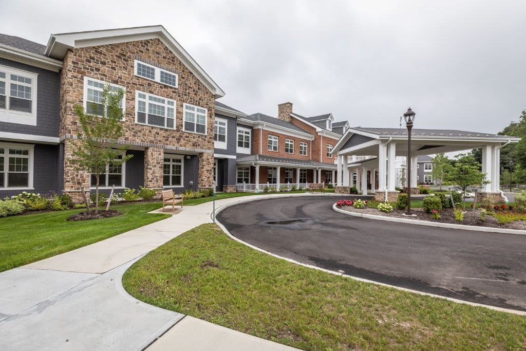 A modern residential building with a driveway and well-maintained lawn.